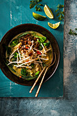 Grünes Hähnchencurry mit Sprossen, Limetten, Chillis und knusprig gebratenen Zwiebeln (Thailand)