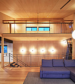 Eleganter Wohnbereich mit doppelter Raumhöhe und Holzverkleidung im Architektenhaus