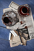 Old newspaper, vintage pewter plate, coffee cups, candles and key