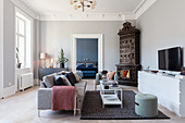 Stucco frieze and antique tiled corner stove in living room of period apartment