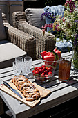 Pastries and fruit on table on sunny terrace