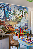 Dragons on mural wallpaper and round tables in playroom