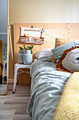 Bett mit Kissen, daneben Nachttisch und Kinderfoto an der Wand
