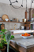 View of sink and shelves across island counter with concrete top