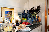 Kitchen counter lavishly decorated with carafes, statues, oil lamps and picture