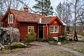 Rotes Schwedenhaus in rustikaler Winterlandschaft mit Felsen