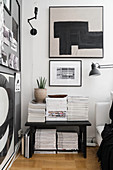 Magazines stacked on bench in black-and-white living room