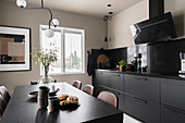 Dining table and black kitchen counter in kitchen-dining room