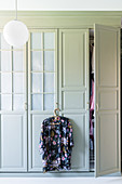 Geblümter Kimono hängt am Kleiderschrank mit Kassettentüren