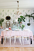 Bistro chairs around set table in classic, feminine dining room