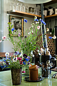Vase of cornflowers and vintage accessories on kitchen table