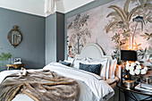 Double bed with headboard and bedside table against large art print in bedroom with grey walls