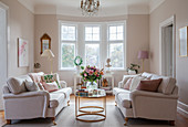 Two sofas facing one another in elegant living room with bay window