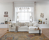 Pale sofa in front of bay window in rustic living room