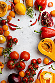 Flatlay with colorful vegetables arranged on white background (Tomatoes, squash and peppers)