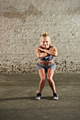 A woman performing a squat with her knees turned in