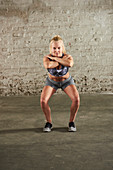 A woman performing a squat with her knees turned out