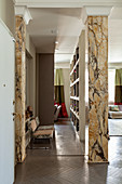 Designer chairs in corridor with marble pillars