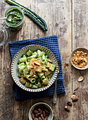 Bowl of palatable pasta paccheri with fresh kale pesto and ground peanuts