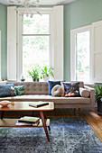 Retromöbel im Wohnzimmer mit Fensterläden und mintgrüner Wand