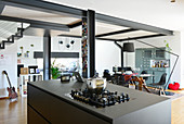 Kitchen island in open-plan loft apartment with steel joists