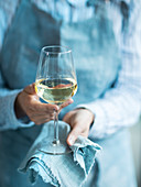 Frau hält ein Glas Weißwein