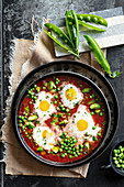 Eier in Tomatensauce mit Erbsen und Zucchini