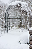 Verschneiter Rosenbogen im Garten