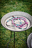 Rings wrapped with fabric for game of quoits in metal dish