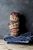 Schokoladen-Bananen-Muffins, gestapelt auf blauem Tuch