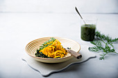 Yellow carrot spirals with vegan pesto made form carrot leaves