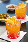 An aperitif with Campari soda, olives and almonds
