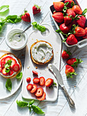 A roll spread with cream cheese and strawberries