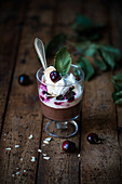 Vegan chocolate semolina pudding with soya yoghurt, cherries, whipped cream and flaked almonds