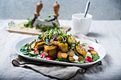 Fried potatoes with a colourful salad and a vegan yoghurt sauce