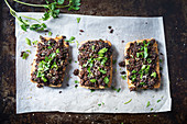 Tofu, überbacken mit Schwarzbrotkruste, garniert mit Petersilie und Sesam (vegan)
