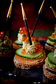 Black bread canapés with cucumber and salmon caviar