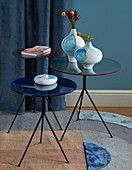 White vases with blue watercolour designs on round side tables