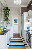 White country-house kitchen with colourful tiled floor in classic period building