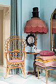 Vintage-Peacock-Chair neben Stehlampe mit Fransenschirm und Ablagefläche