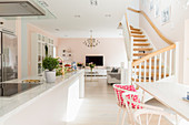 Island counter, dining area, staircase and TV area in open-plan interior