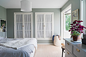 Classic bedroom in pale grey and white with fitted wardrobes