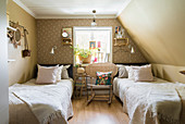 Twin beds in attic bedroom with vintage-style ambience