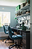 Black desk and hobby workbench with two blue swivel chairs