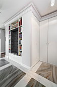 Upholstered niche surrounded by bookshelves in hall