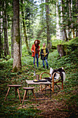 Girl and woman having autumnal picnic in woods
