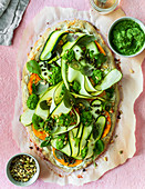 A pizza with courgette, herbs and pesto