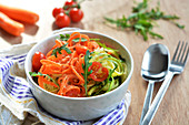 Vegetable spaghetti made with carrots and courgette, fresh tomatoes and rocket