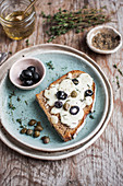 Cheese toast with black olives, capers and fresh thyme