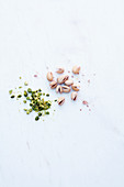 Pistachio shells and chopped pistachios on a white surface